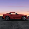 Sleek Red Sports Car Parked On Concrete Ground During Sunset Sky