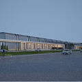 Modern Industrial Factory Building Facade With Glass Windows Evening Lights And Landscaped Surroundings