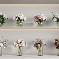 Various Glass Vases With Colorful Flowers Displayed On White Shelves For Home Decor