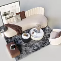 Beige Curved Sofa with Pillows Throw Blanket Round White Coffee Table and Black Table on Gray Rug