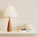 Wooden Conical Table Lamp With Golden Rod And White Lampshade Near Textured Vase On Books