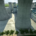 Industrial Plant Exterior Featuring Tall Concrete Cooling Towers And Surrounding Buildings