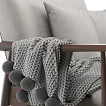 Cozy Gray Armchair With Wooden Frame Pillows And Pom Pom Blanket