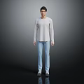 Man in Light Gray Long Sleeve Top and Light Blue Jeans Standing Against Dark Background