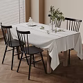 Stylish Dining Table With White Tablecloth Black Chairs And Green Plant Decoration
