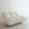White Upholstered Single Sofa With Plush Cushions In Modern Minimalist Interior