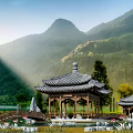 Traditional Chinese Pavilion With Wooden Structure Tiled Roof And Mountain Pond Scenery