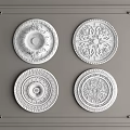 Four Decorative Ceiling Medallions With Intricate Patterns On Gray Wall