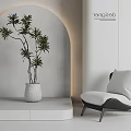 Modern Leisure Chair Interior Design With White Planter Green Plant Gray Wall And Soft Lighting