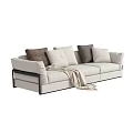 Modern Beige Three-Seater Sofa with Brown and White Pillows and Cozy Blanket