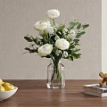 Transparent Glass Vase With White Flowers And Green Leaves On Wooden Table With Books