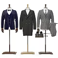 Three Different Style Suits Displayed on Mannequins with Shoes and Trousers Nearby