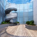 Modern Spiral Staircase In Bright Interior With Glass Walls Greenery And Wooden Flooring