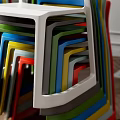 Black Leisure Chair With Colorful Stacked Chairs On Wooden Herringbone Floor Interior