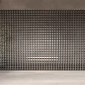 Black Grid Like Partition In Indoor Space With Gray Walls Light Colored Floor And Plant