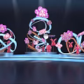 Decorative Art Installations With Pink Flowers Butterflies And Blue Curved Structures On Lit Platform