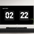 Modern TV Displaying April 2022 Date 02 22 On Black Stand With Plant