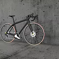 Sleek Silver Road Bicycle With Curved Handlebars Red Yellow Rim Accents Against Gray Wall