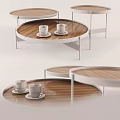 Modern Round Coffee Table With Wooden Top White Metal Legs And Coffee Cups On Saucers