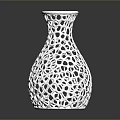 Green Plants In White Perforated Vase With Hollow Out Design On Black Surface