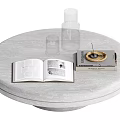 Light Colored Round Table With Open Book And Golden Cover Book Transparent Bottle Small Cup