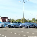 Luxury Sports Cars Parked In Urban Parking Lot With Street Lamps And Church Dome