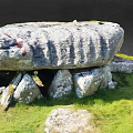 Outdoor Stone Structure With Large Top Slab And Supporting Stones On Green Grass