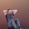 Man Sitting with Hands Behind Head in Gray T-shirt and Pants on Warm Gradient Background