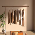 Minimalist Clothes Rack With Neutral Tones Coats And Green Plant Against Light Wall
