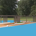 Outdoor Pergola with Wooden Floor Metal Railings and Platform by Classic Mansion Surrounded by Trees