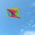 Colorful Diamond Shaped Kite With Streamers On Light Blue Background