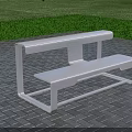 White Metal Roadside Bench On Gray Brick Pavement With Green Lawn Background
