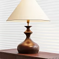 Elegant Table Lamp With White Lampshade And Brown Vase Shaped Base Against Window Blinds