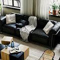 Black Leather Multi Person Sofa With Pillows And Knitted Blanket In Bright Living Room