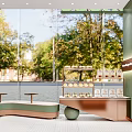 Sweet Dessert Shop Interior With Green Walls Wooden Accents And Glass Display Cases