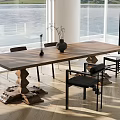 Wooden Dining Table Set With Sculptural Base Black Upholstered Chairs And Vase By Large Windows