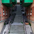 Narrow Alleyway With Red Brick Buildings Green Awnings Street Lamps And Stone Stairs