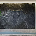 Natural Garden Landscape With Black Stone Wall And Potted Pine Tree Design