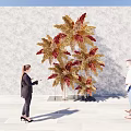 People Posing At Check in Photo Spot With Large Decorative Plant And Golden Red Leaves