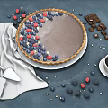 Fresh Chocolate Tart Topped With Blueberries Raspberries And Chocolate Pieces With Coffee Knife And Napkin