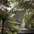 Unique Triangular Guesthouse Architecture With Sharp Metal Roof And Warm Lighting Surrounded By Trees