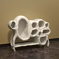 White Abstract Sculpture Carving with Hollow Holes and Textured Surface in Indoor Setting
