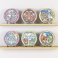 Various Handmade DIY Decorative Plates With Colorful Cartoon Patterns On Wooden Shelves