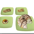 Assorted Desserts on Green Square Plates Featuring Fruit Tart Long Pastries and Chocolate Drizzle Ring