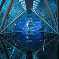 Amusement Park Indoor Attraction With Glass Dome Blue Lighting Reflective Floor And Geometric Frame Design