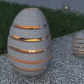 Outdoor Stone Egg Lanterns With Hollow Striped Design And Warm Light On Grass Gravel