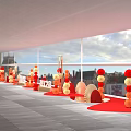 Indoor Celebration Setup With Red Orange Balloons Fan Shaped Decorations And Large Windows