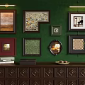 Green Wall With Multiple Frames And Dark Wooden Cabinet With Books Box Fruits And Plant