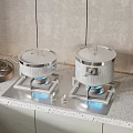 Kitchen Gas Stove With Silver Pots Blue Flames Metal Tray And Cups On Countertop