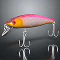 Shiny Pink And Yellow Fishing Lure With Metal Hooks And Clear Reflections